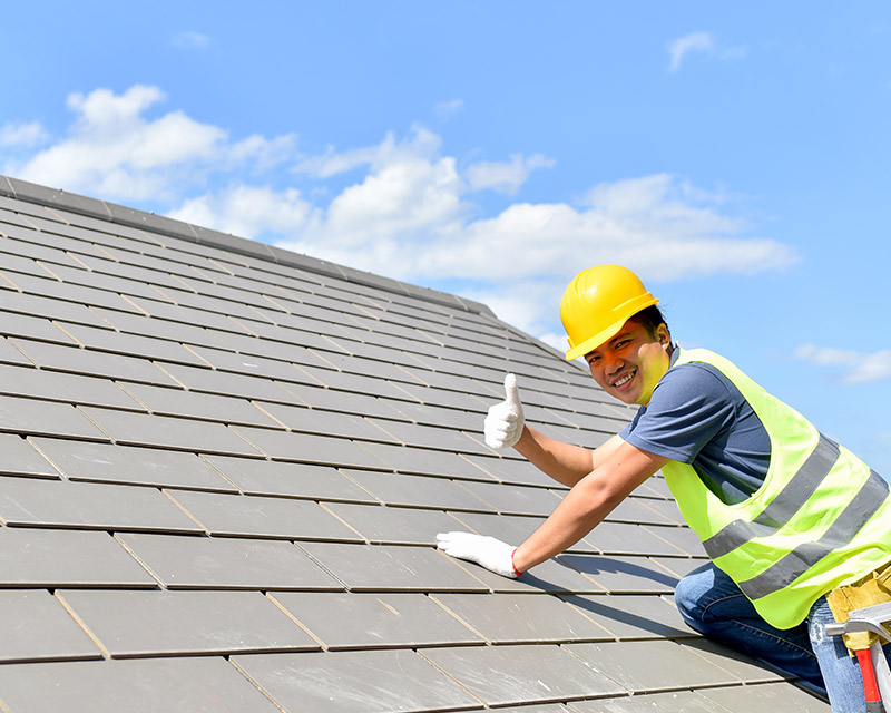 Worker installing roof tiles
